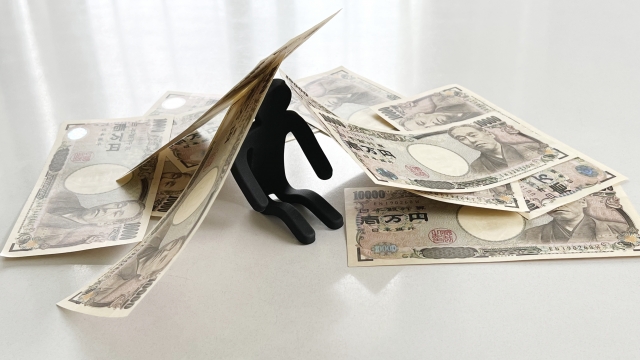 お金の上でうなだれる。川越市で借金返済の無料相談ができます